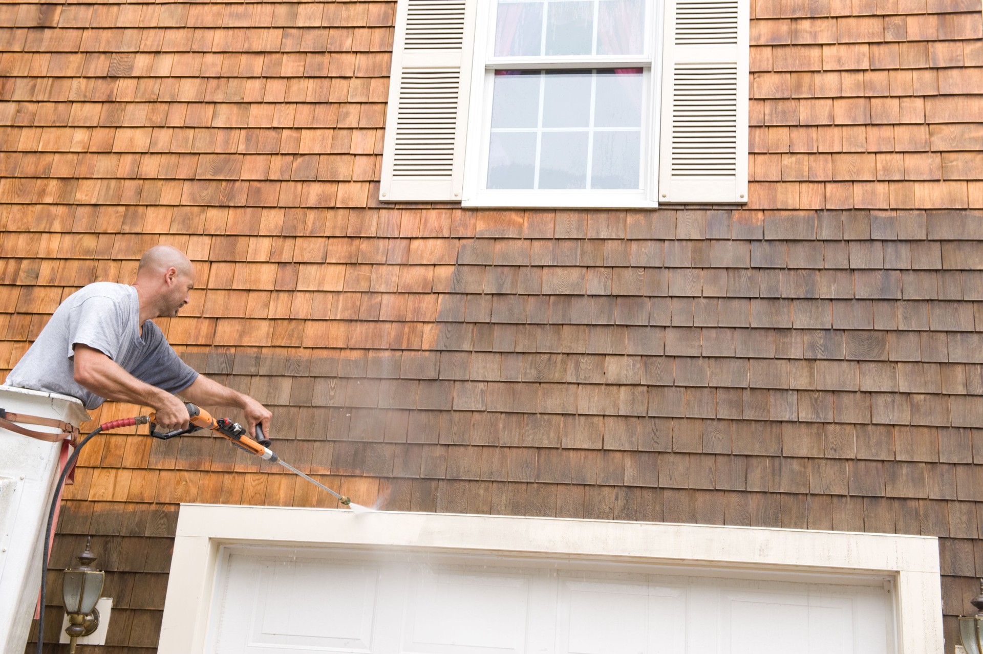Man Power Washing exterior shingles